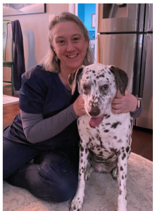 Dr Jess smiling and sitting with a dalmation